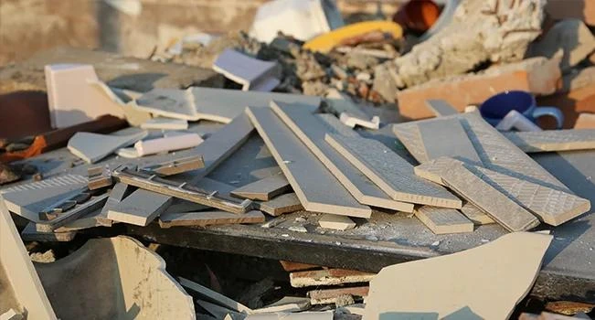 Pilha de restos de materiais de construção e revestimentos em um canteiro de obras.