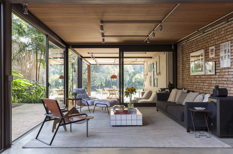Casa com estrutura aparente e tijolo maciço destacando materiais naturais na arquitetura