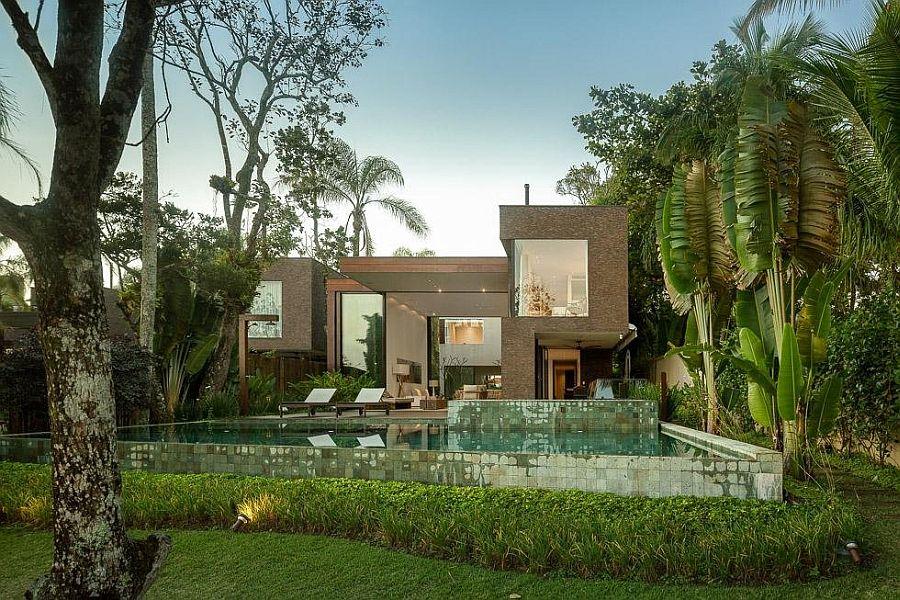 Casa contemporânea integrada à natureza com arquitetura moderna e paisagismo.