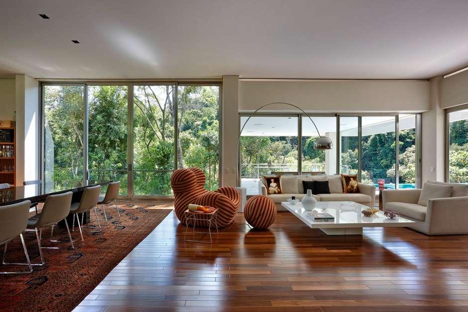 Sala contemporânea com grandes esquadrias e iluminação natural.